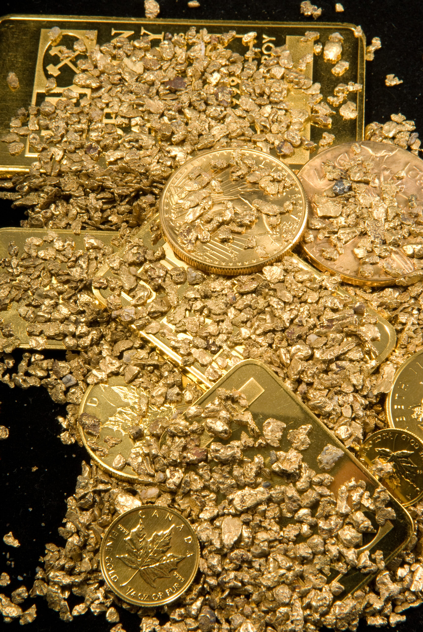 Große Proben von reinem Gold in verschiedenen Formen, einschließlich Münzen, Barren, Stäben, Staub und Nuggets.